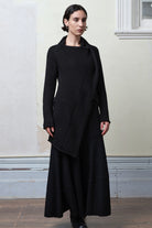 Model wears knitted merino cross over, in black colourway.