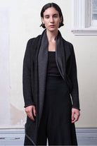 Model wears knitted merino cross over, slung behind, in black and charcoal colourway.