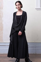 Model wears knitted merino cross over, undone in black and charcoal colourway.