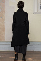 Model wears black knitted coat , made from alpaca and superfine merino wool. Designed and made in Melbourne by Wendy Voon Knits