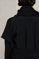 Close up fabric view of black knitted coat made from alpaca and superfine merino wool