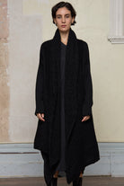 Model wears black knitted coat , made from alpaca and superfine merino wool. Designed and made in Melbourne by Wendy Voon Knits