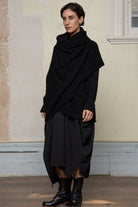 Model wears black knitted coat upside down, made from alpaca and superfine merino wool.