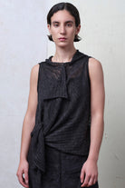 Model wears charcoal linen laddered vest cinched at the waist. Designed and knitted in Melbourne by Wendy Voon knits.