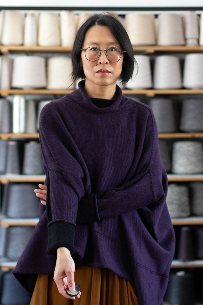 Front view of box shaped jumper designed by Wendy Voon, in eggplant with black backed fabric, made from superfine merino wool.