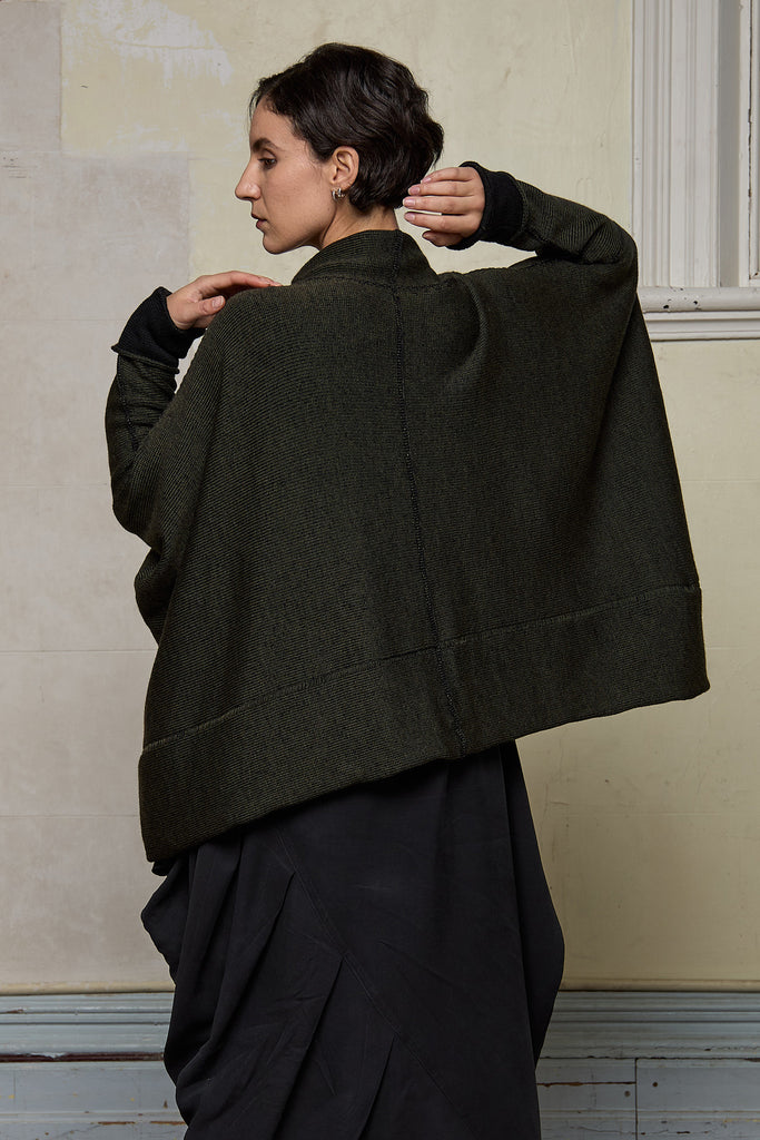 Back view of box shaped jumper designed by Wendy Voon, in an army with black backed fabric, made from superfine merino wool.