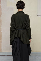 Back view of box shaped jumper, worn belted.  Designed by Wendy Voon, in an army with black backed fabric, made from superfine merino wool.