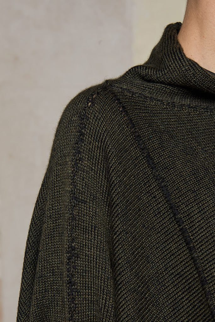 Fabric view of box shaped jumper designed by Wendy Voon, in an army with black backed fabric, made from superfine merino wool.