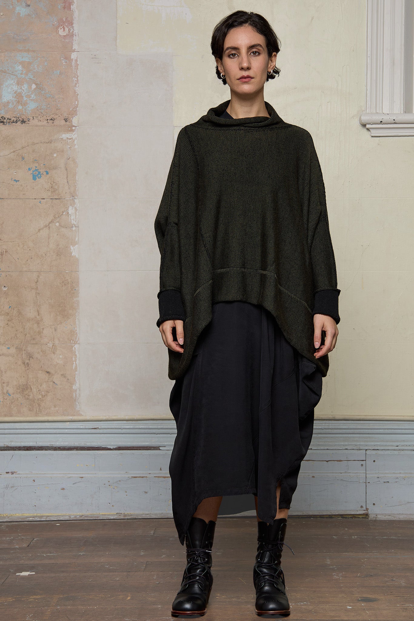 Front view of box shaped jumper designed by Wendy Voon, in an army with black backed fabric, made from superfine merino wool.