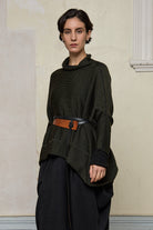 Front view of box shaped jumper designed by Wendy Voon, in an army with black backed fabric, worn belted. Made from superfine merino wool.