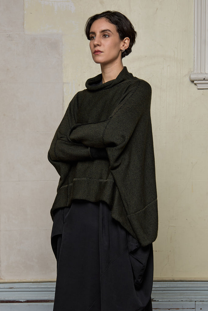 Front view of box shaped jumper designed by Wendy Voon, in an army with black backed fabric, made from superfine merino wool.
