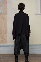 Back view of box shaped jumper designed by Wendy Voon, in a burgundy with black backed fabric, worn inside out. Made from superfine merino wool.
