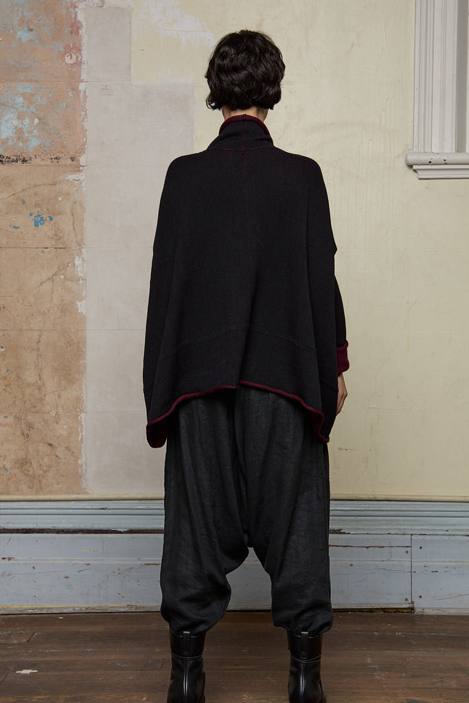Back view of box shaped jumper designed by Wendy Voon, in a burgundy with black backed fabric, worn inside out. Made from superfine merino wool.