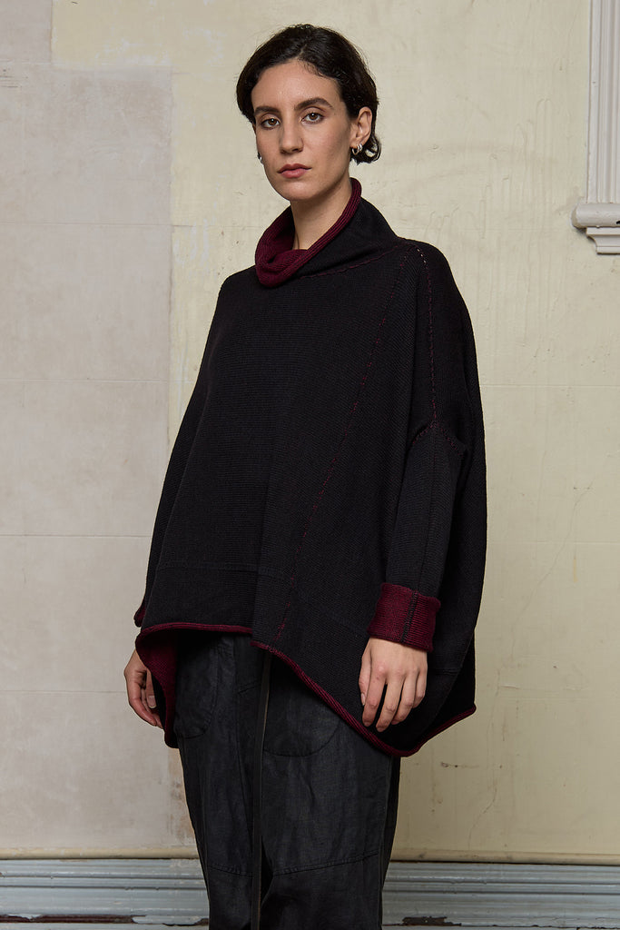 Front view of box shaped jumper designed by Wendy Voon, in a burgundy with black backed fabric, worn inside out.  Made from superfine merino wool.