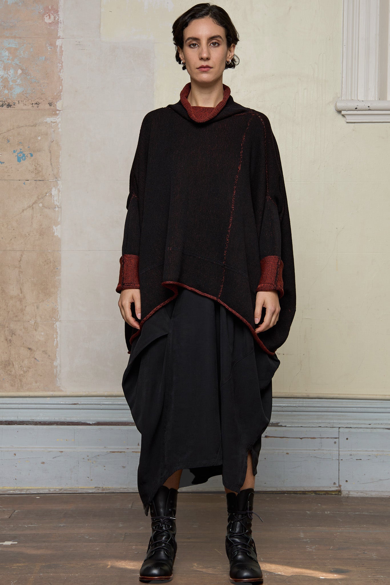 Front view of box shaped jumper designed by Wendy Voon, in a vermillion with black backed fabric, worn inside out. Made from superfine merino wool.
