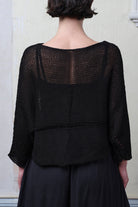 Front view of model wearing Cotton Batwing  in black colourway, featuring lace details along garment seam,  designed by Wendy Voon knits.