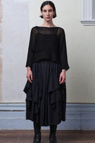 Front view of model wearing Cotton Batwing  in black colourway, featuring lace details along garment seam,  designed by Wendy Voon knits.