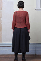 Back view of model wearing Cotton Batwing  in coral colourway, featuring large stitch details,  designed by Wendy Voon knits.