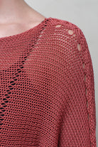 Close up fabric detail of Cotton Batwing  in coral colourway, featuring large stitch details,  designed by Wendy Voon knits.