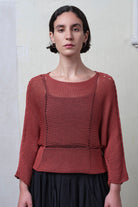 Front view of model wearing Cotton Batwing  in coral colourway, featuring large stitch details,  designed by Wendy Voon knits.