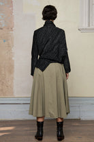Full body back view of Bias jumper, a design by Wendy Voon knits in a black flecked with white merino wool and linen/cotton blend fabric. 