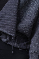 Close up fabric view of grey with white flecked wool ruched cardigan.
