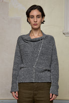 Front view of model wearing wool boucle knitted jumper in grey melange with decorative external seam details.