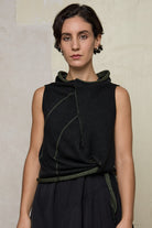 Model wears knitted asymmetric self-curling vest inside out, in army green on black colourway. Designed and knitted in Melbourne by Wendy Voon knits.