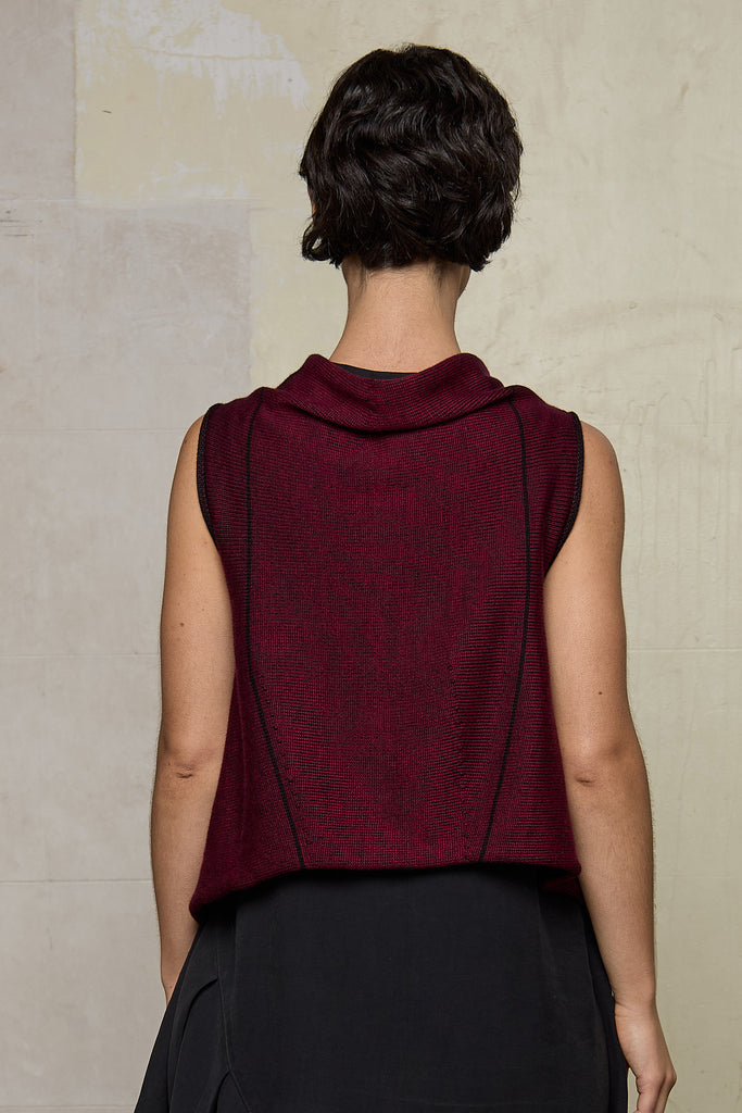 Model wears knitted asymmetric self-curling vest, in burgundy on black colourway. Designed and knitted in Melbourne by Wendy Voon knits