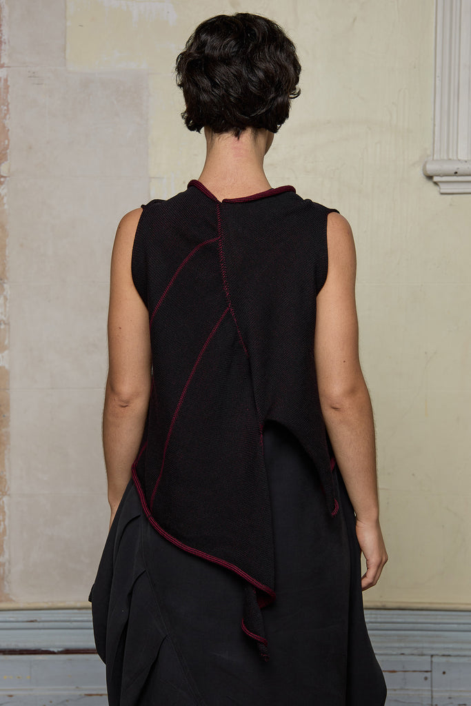 Model wears knitted asymmetric self-curling vest inside out, in burgundy on black colourway. Designed and knitted in Melbourne by Wendy Voon knits