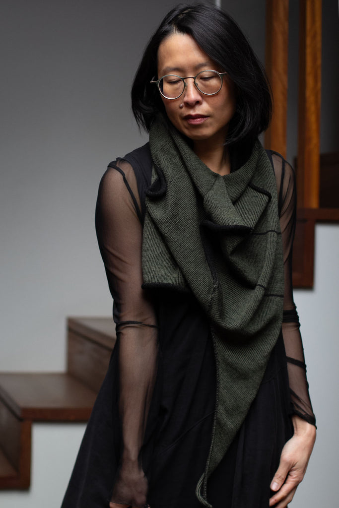 Model wears an asymmetric self-curling vest as scarf.  Vest is knitted in superfine merino wool,in an army backed with black colourway, designed and knitted in Melbourne by Wendy Voon knits.