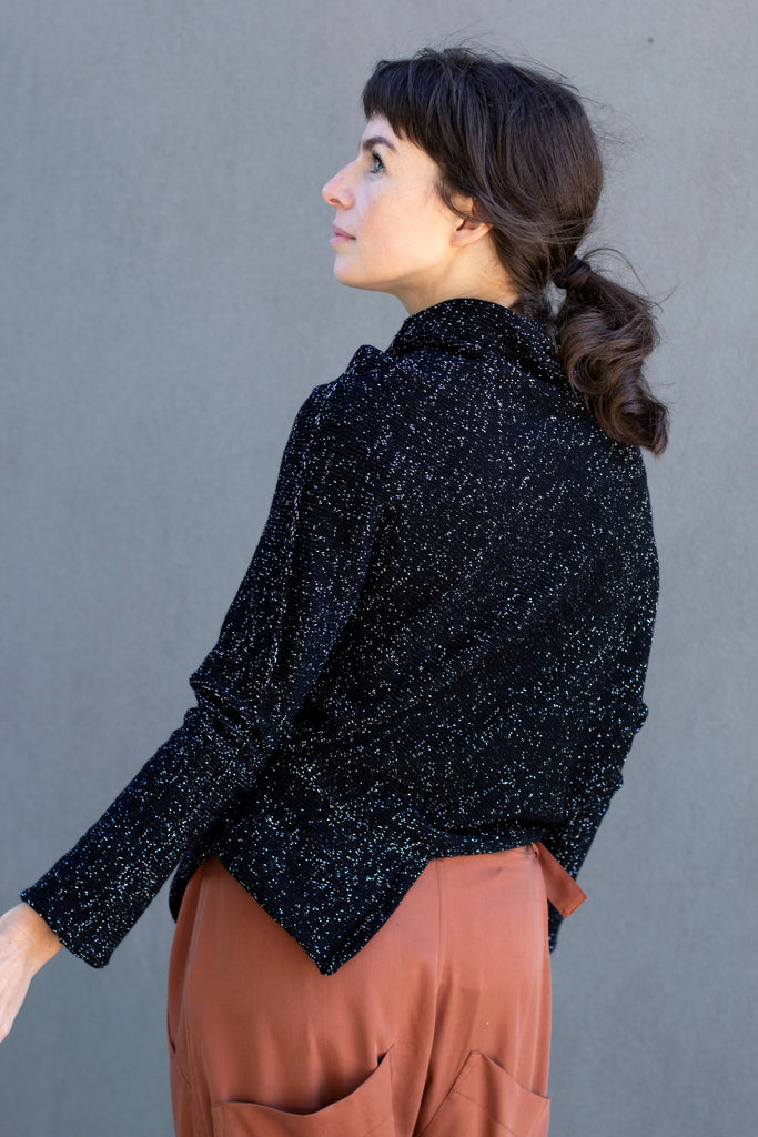 Back view of Bias jumper, a design by Wendy Voon knits in a sparkly black  merino wool and lurex blend fabric. 