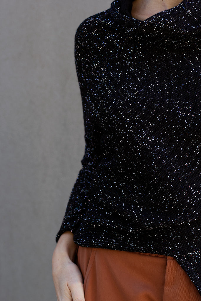 Close up view of Bias jumper, a design by Wendy Voon knits in a sparkly black  merino wool and lurex blend fabric. 