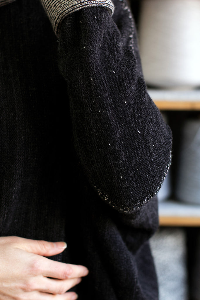 Sleeve detail of reversible box shaped jumper designed by Wendy Voon, made from superfine merino wool, with black colourway showing.