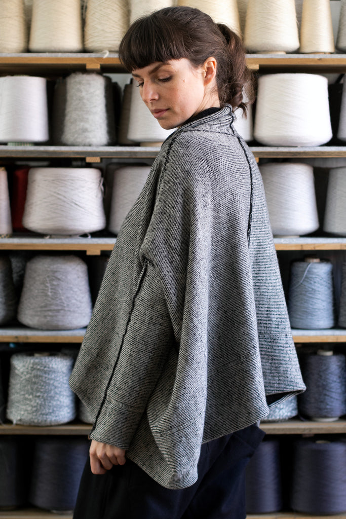 Side view of reversible box shaped jumper designed by Wendy Voon, made from superfine merino wool, with cream colourway showing.