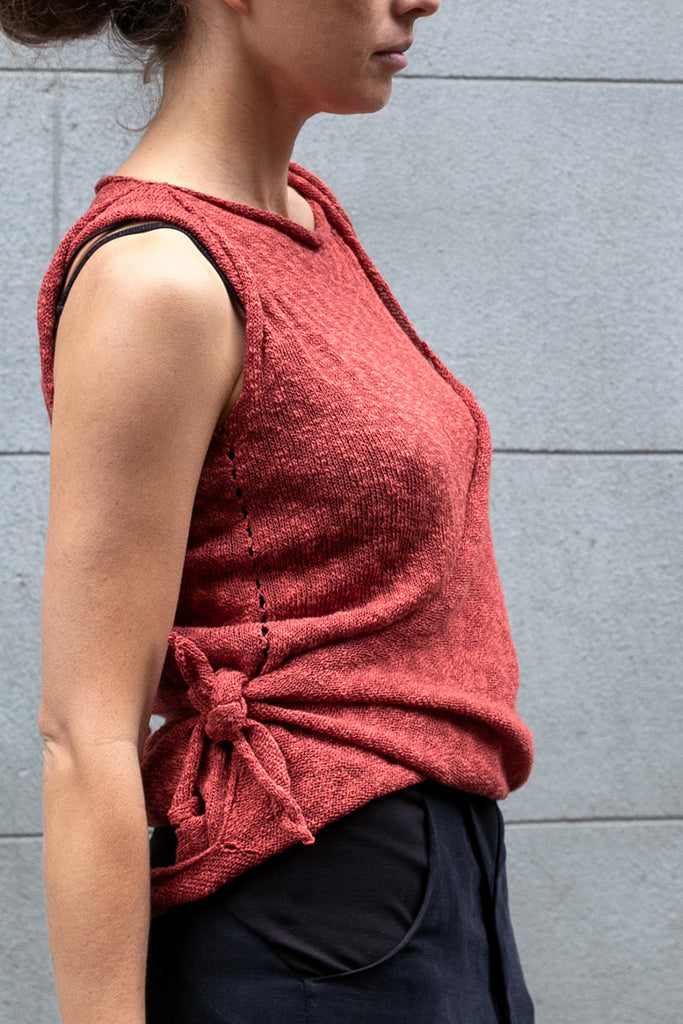 Side view of Double Up Top design by Wendy Voon knits in coral linen cotton, loop worn long and knot side detail