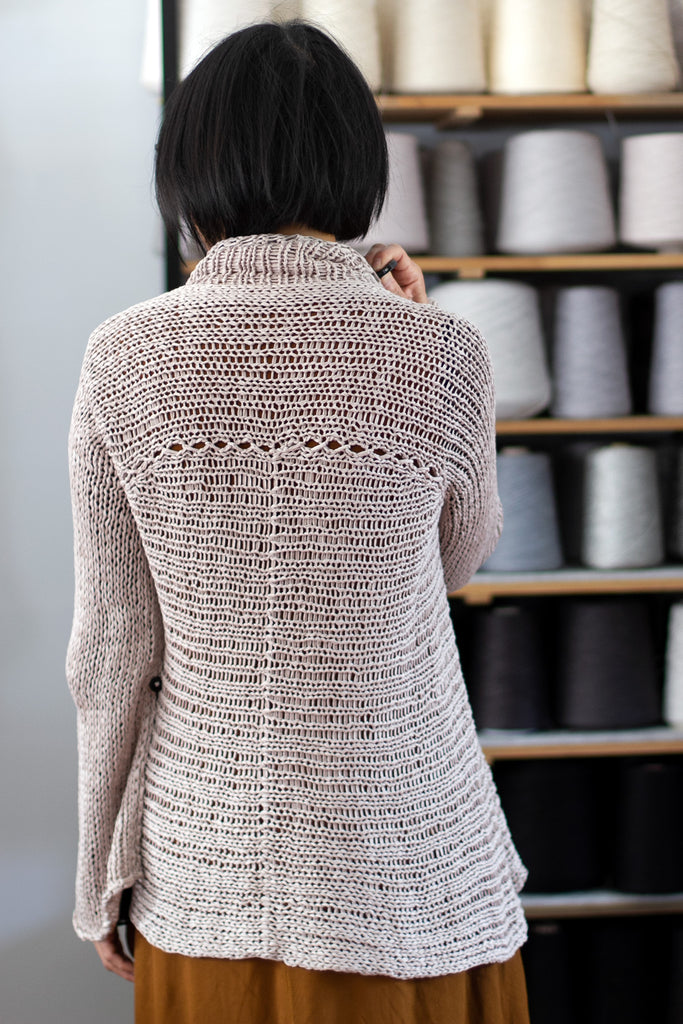 Back view of dusty coloured open knit cotton jumper with funnel neck, designed and knitted by Wendy Voon