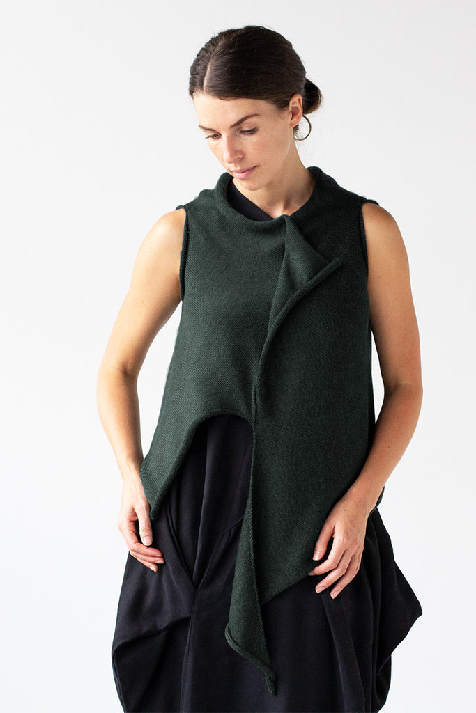 Front view of Asymmetric Self Curling Vest design by Wendy Voon knits in deep forest green merino wool