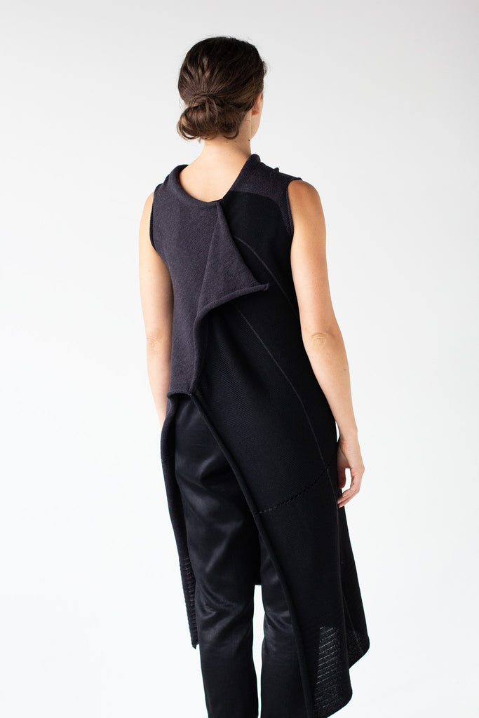 Back view of Two Toned Asymmetric Longline vest in charcoal and black, worn back to front with asymmetric hem at back