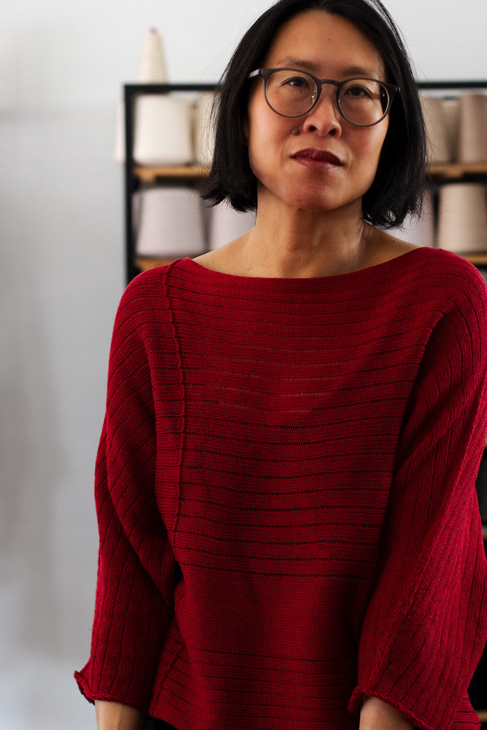 Close up front view of raspberry coloured linen/cotton knitted batwing, designed by Wendy Voon and knitted in Melbourne.