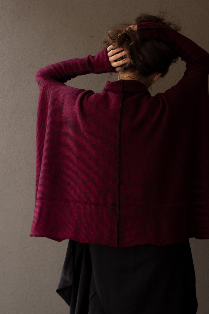 Back view of box shaped jumper designed by Wendy Voon, in a burgundy with black backed fabric, made from superfine merino wool.