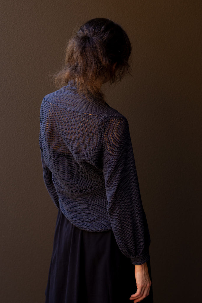 Back profile of model wearing slate cotton cowl neck jumper, designed  and knitted in Melbourne by Wendy Voon knits