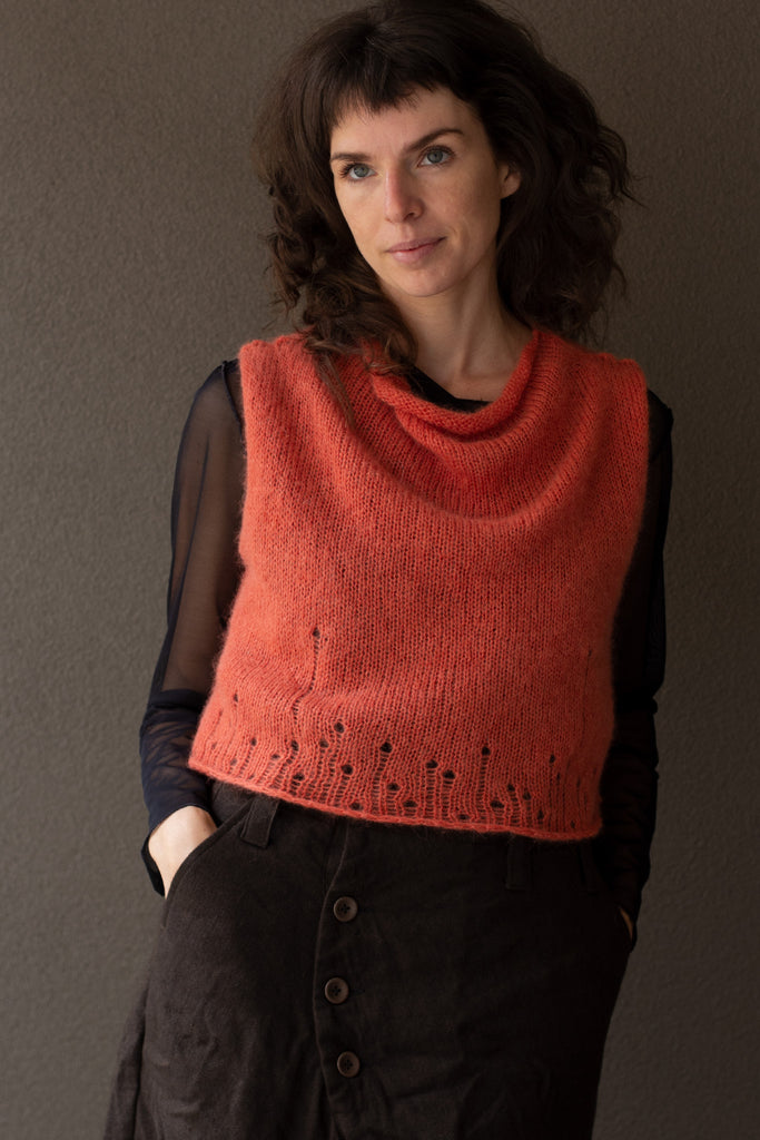 Front view of super soft knitted vest in a carrot colourway, featuring laddered laceholes, made from baby alpaca, mohair and silk. Designed and made in Melbourne by Wendy Voon knits