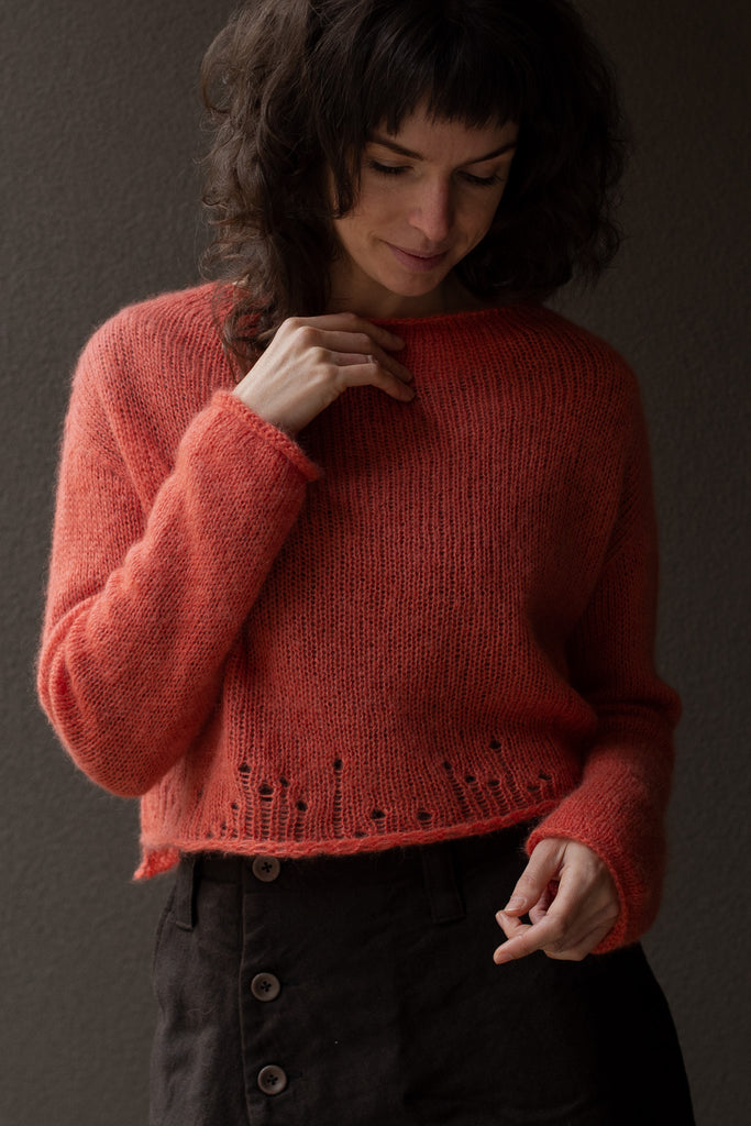 Front view of super soft knitted jumper in a carrot colour way, featuring laddered laceholes, made from baby alpaca, mohair and silk. Designed and made in Melbourne by Wendy Voon knits