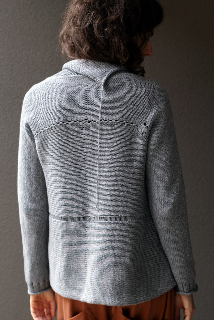 Back view of  superfine merino wool/polyamide soft grey jumper, designed by Wendy Voon knits, made in Melbourne.  Jumper features triangular panels at front with loose threads left as design feature