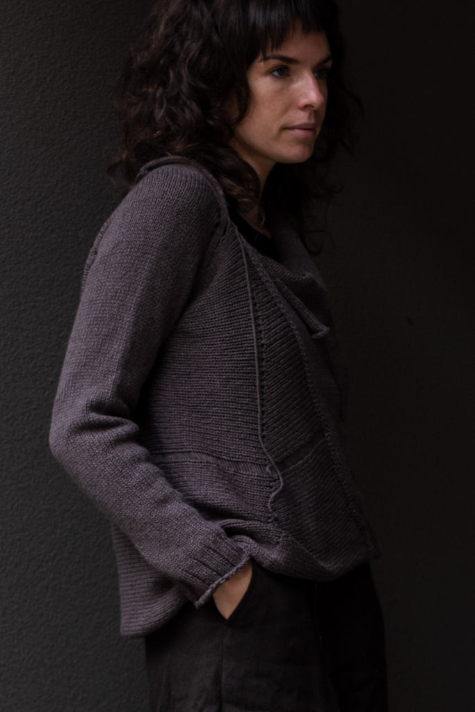 Side view of taupe superfine merino wool/polyamide jumper, designed by Wendy Voon knits, made in Melbourne.  Jumper features triangular panels at front with loose threads left as design feature