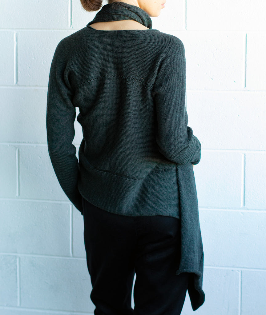 Back view of the Merino Cross Over by Wendy Voon in deep forest green, worn with front looped as a closed asymmetric cardigan