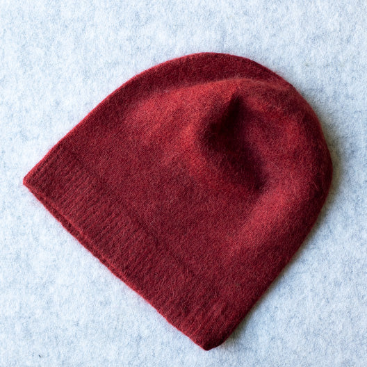 Red coloured knitted beanie made from merino wool, possum and silk