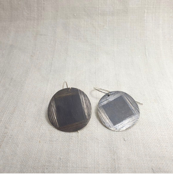 Round dangling earrings, made from oxidised silver with hand etched detail.