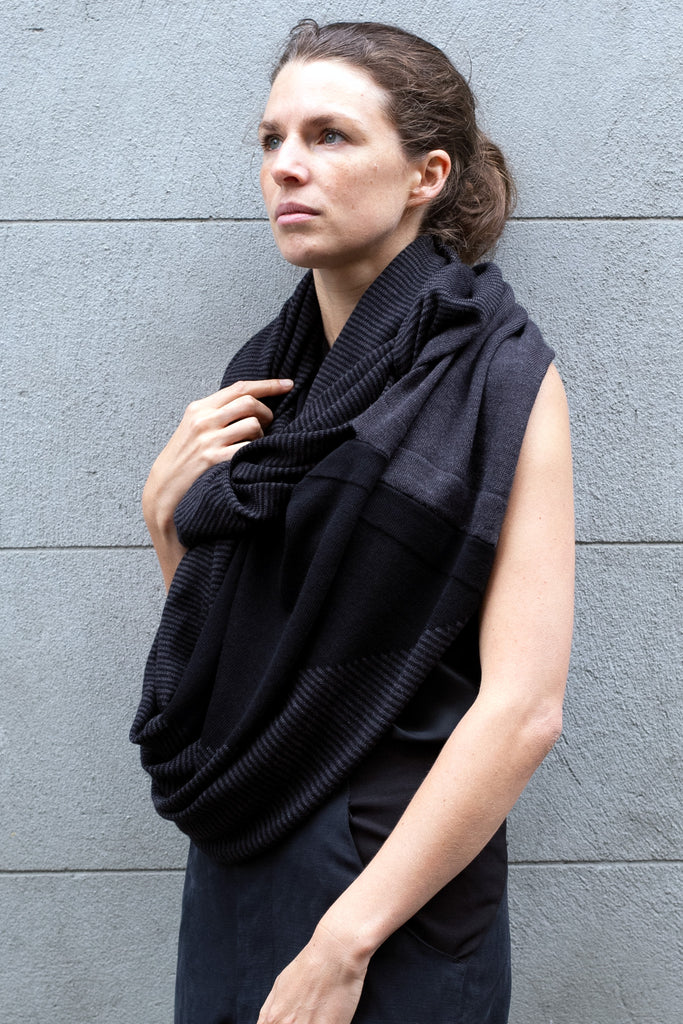Front view of Striped Wrap design by Wendy Voon knits in black and charcoal merino wool, worn as scarf